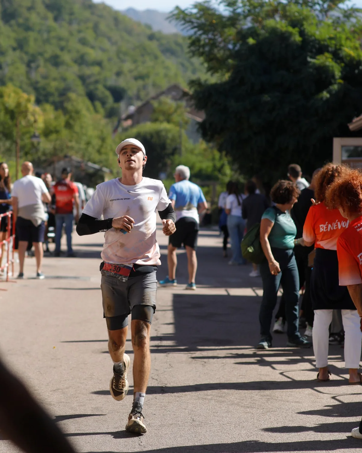 Florian Mouchel à l'arrivée du Bastelica Trail, dossard 330, maillot « Diététicien du sport » taché de boue